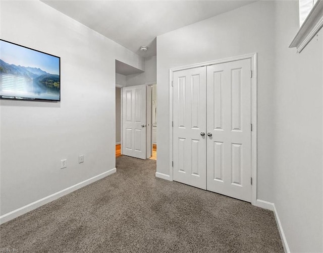 unfurnished bedroom with a closet, baseboards, and carpet floors