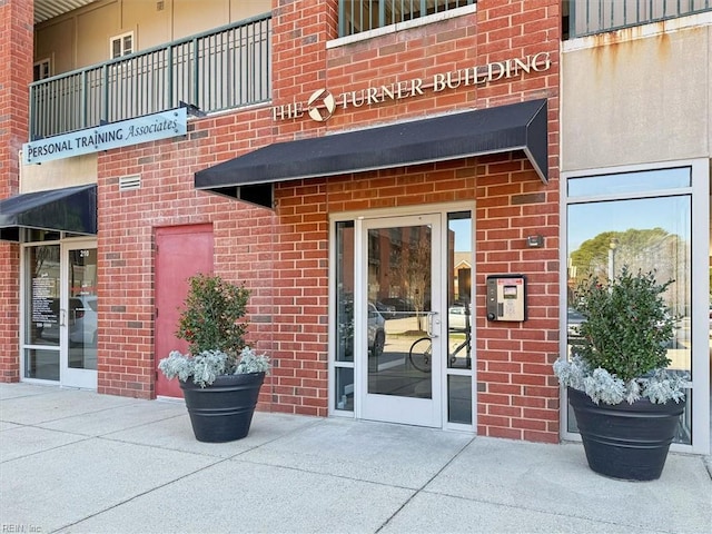 view of exterior entry with brick siding