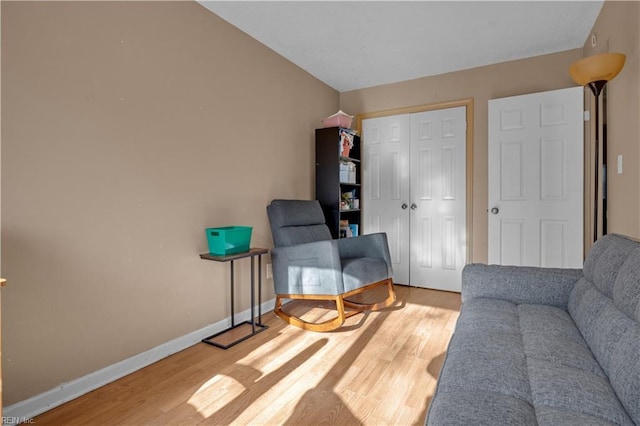 living area with light wood-style flooring and baseboards