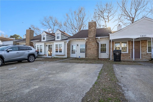 view of front of home featuring brick siding and a chimney