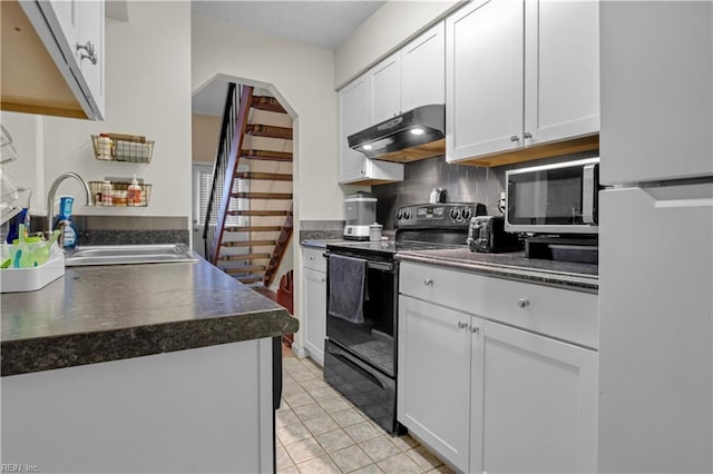 kitchen featuring dark countertops, stainless steel microwave, under cabinet range hood, black electric range, and a sink