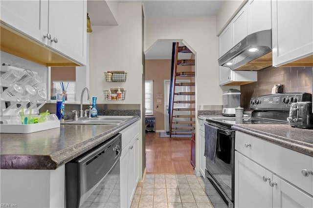 kitchen featuring black appliances, under cabinet range hood, a sink, backsplash, and white cabinetry