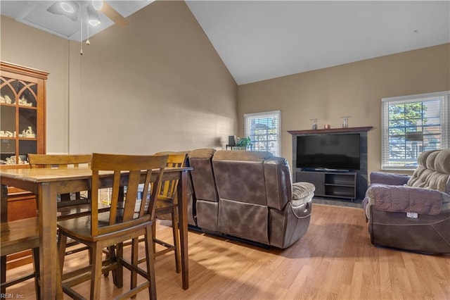 living area featuring light wood-style flooring, high vaulted ceiling, and ceiling fan