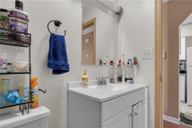 half bathroom featuring visible vents, toilet, and vanity