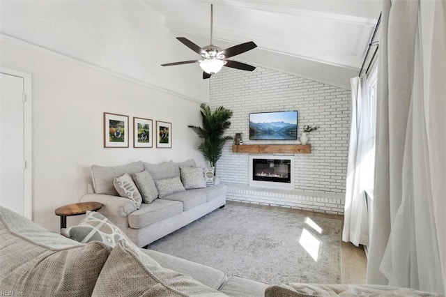 living room with a fireplace, lofted ceiling with beams, wood finished floors, and a ceiling fan