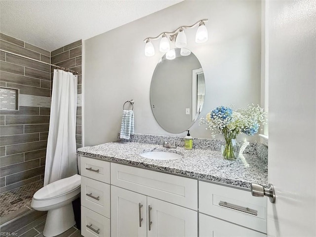 full bathroom with tiled shower, toilet, vanity, and a textured ceiling