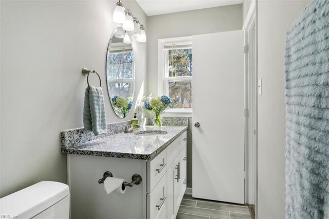 half bathroom featuring toilet and vanity