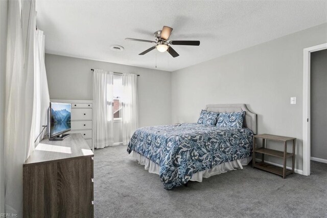 bedroom featuring baseboards, a textured ceiling, a ceiling fan, and carpet floors