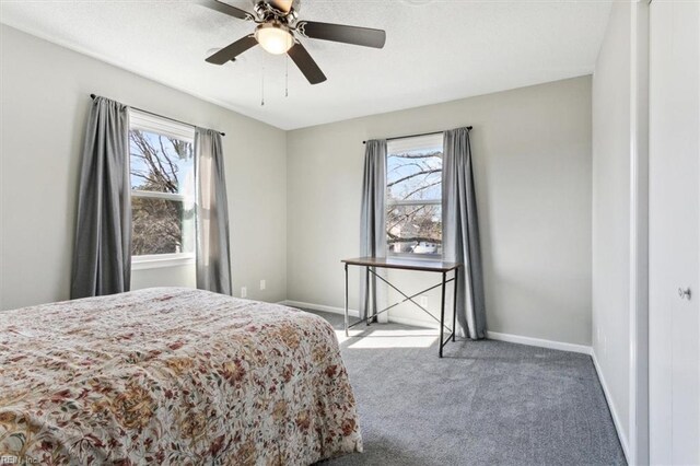 bedroom featuring baseboards, multiple windows, ceiling fan, and carpet flooring