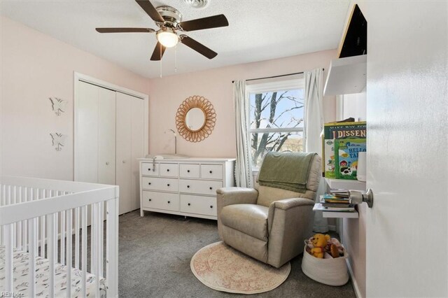 bedroom featuring a closet, carpet flooring, ceiling fan, and a nursery area