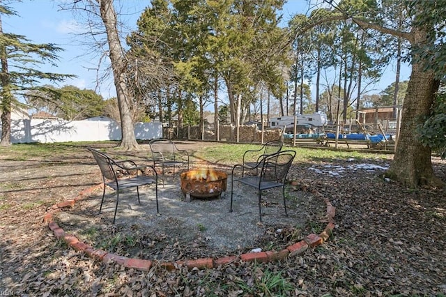 view of yard with a fire pit and fence