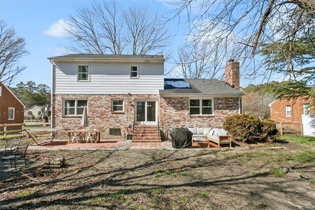 back of house featuring fence, brick siding, outdoor lounge area, and entry steps