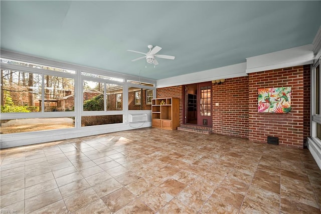 unfurnished sunroom with an AC wall unit and ceiling fan