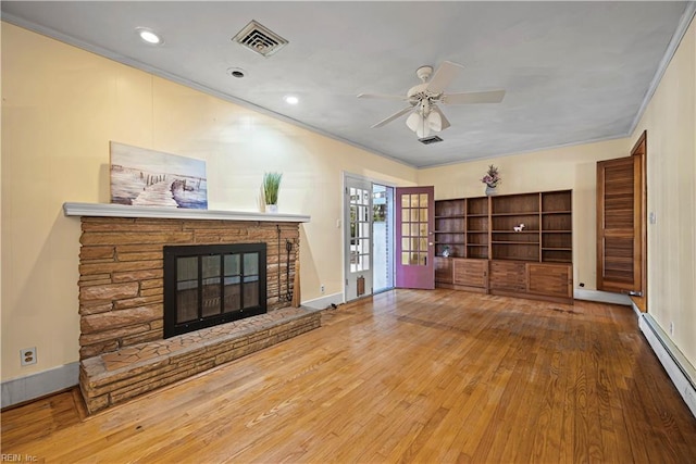 unfurnished living room featuring visible vents, a ceiling fan, a baseboard heating unit, a glass covered fireplace, and wood finished floors