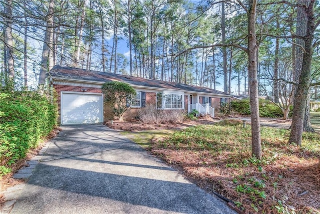 ranch-style house with brick siding, an attached garage, and driveway