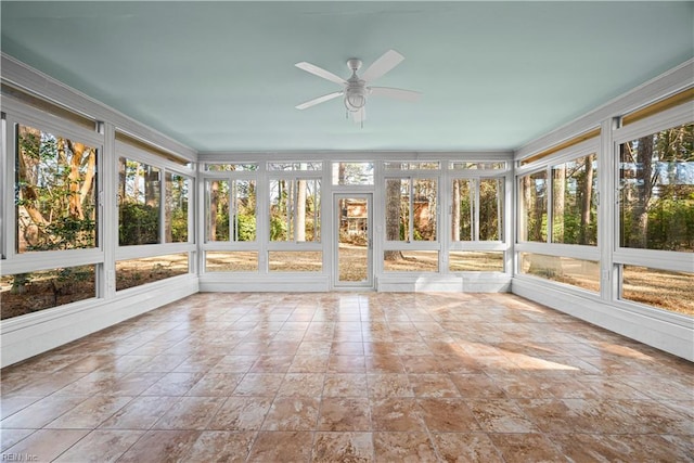 unfurnished sunroom featuring a ceiling fan