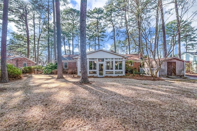 rear view of property with an outbuilding and a sunroom