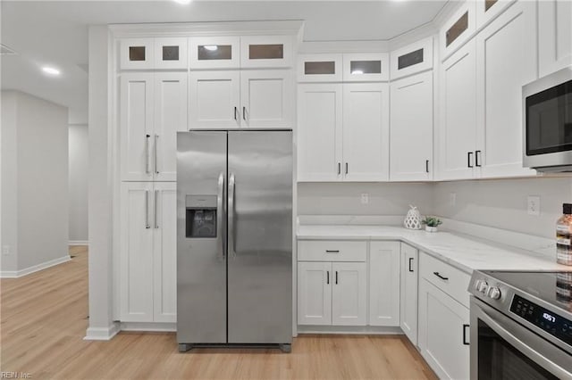 kitchen featuring white cabinets, light wood-style floors, and appliances with stainless steel finishes