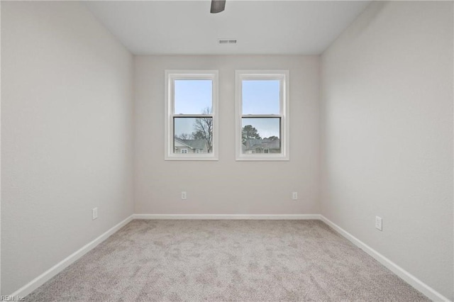 carpeted empty room with visible vents and baseboards