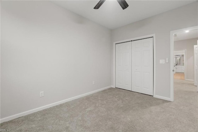 unfurnished bedroom featuring a closet, baseboards, a ceiling fan, and carpet flooring