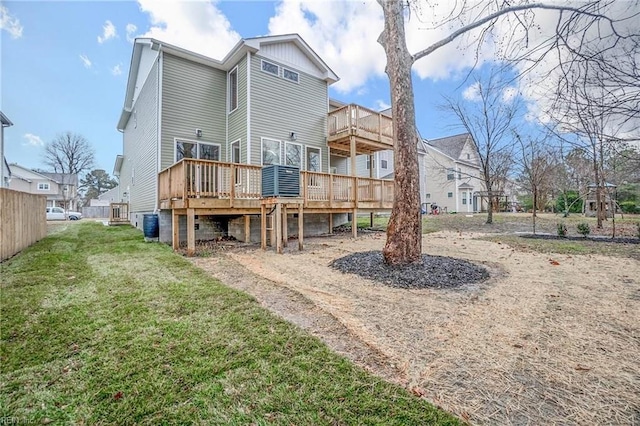 back of property with a deck and a lawn