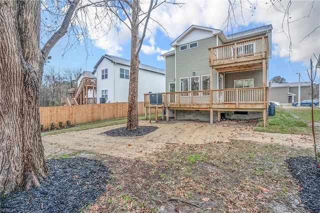 rear view of property featuring central air condition unit, a wooden deck, a balcony, and fence