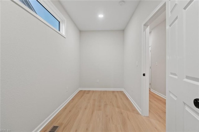 empty room featuring visible vents, light wood-style flooring, and baseboards