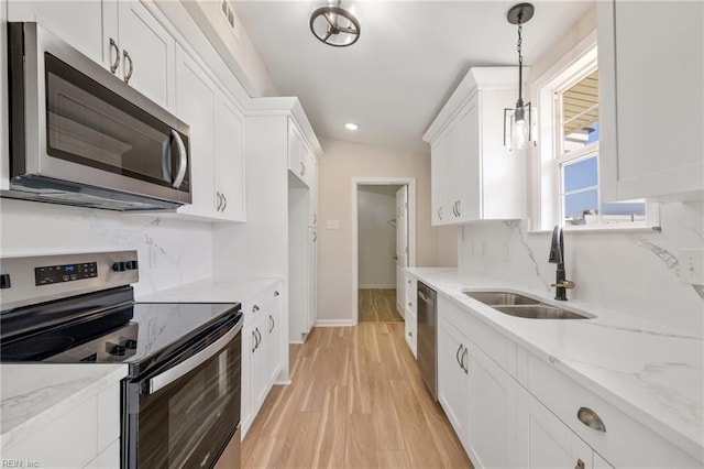 kitchen with white cabinetry, backsplash, appliances with stainless steel finishes, and a sink