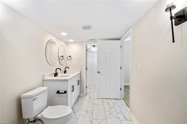 bathroom with visible vents, toilet, marble finish floor, baseboards, and vanity