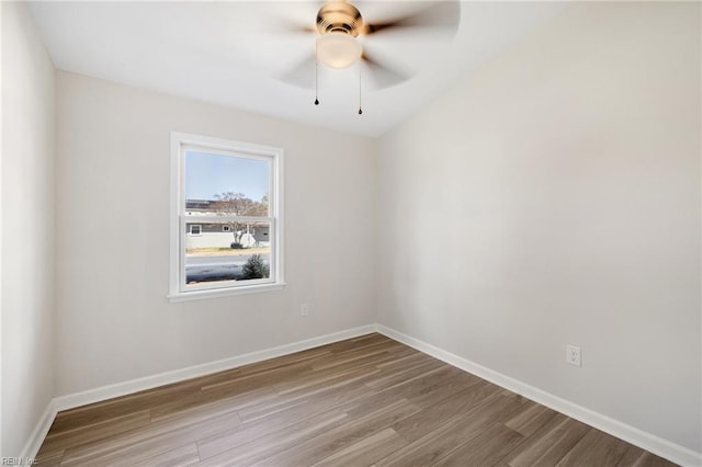 empty room featuring wood finished floors, baseboards, and ceiling fan