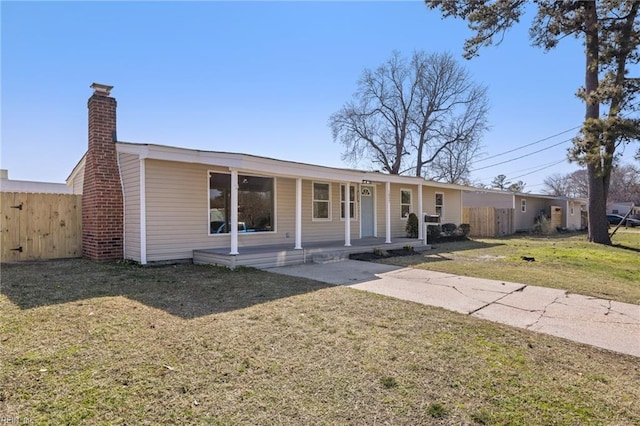 single story home with a porch, fence, a front yard, and a chimney