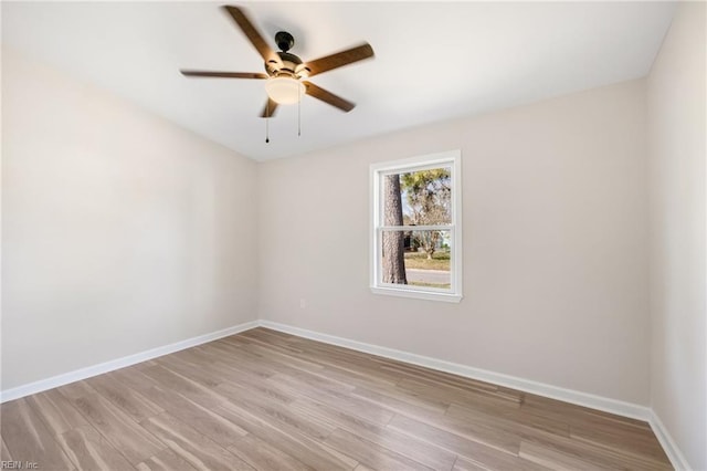 spare room featuring light wood-style flooring, baseboards, and ceiling fan