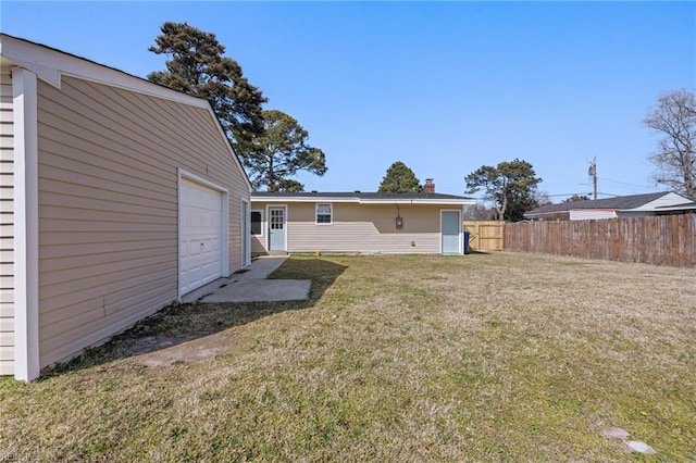 view of yard featuring a garage and fence