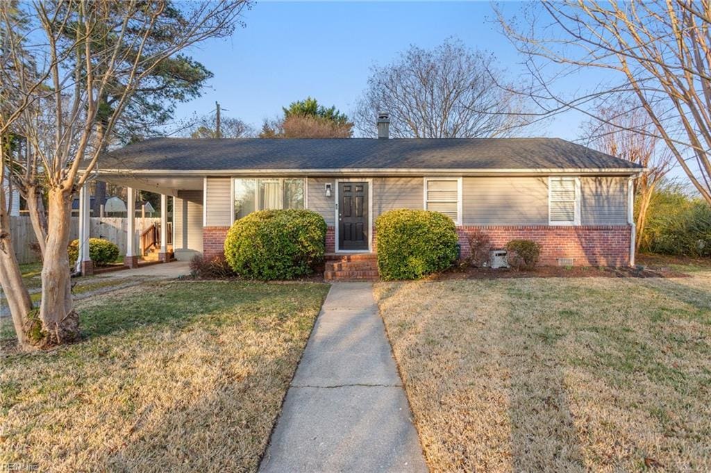 ranch-style house featuring a front yard and brick siding