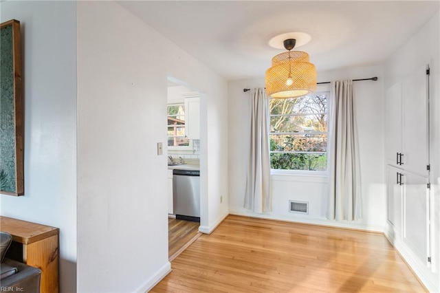 dining space with baseboards, visible vents, and light wood finished floors