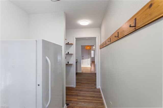 hall featuring dark wood-type flooring and baseboards