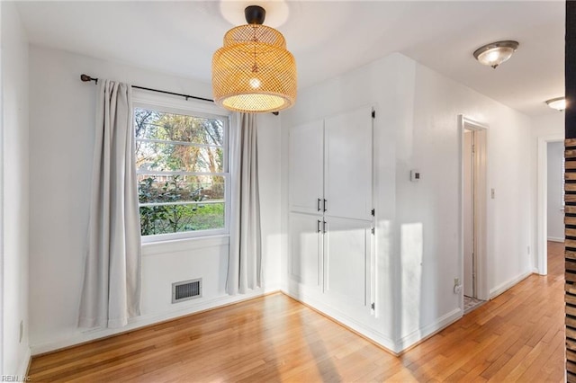 interior space with light wood-style flooring, baseboards, and visible vents