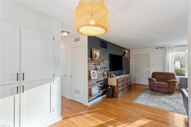 living area featuring visible vents and light wood-style floors