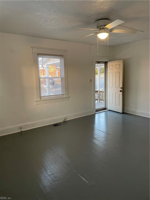 unfurnished room with baseboards, visible vents, and ceiling fan