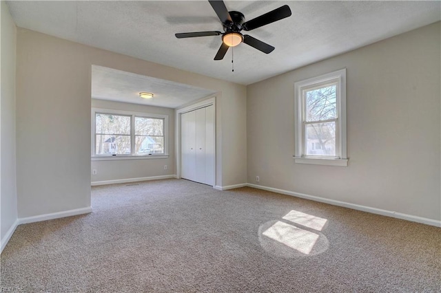 unfurnished bedroom featuring a ceiling fan, baseboards, carpet floors, a closet, and a textured ceiling