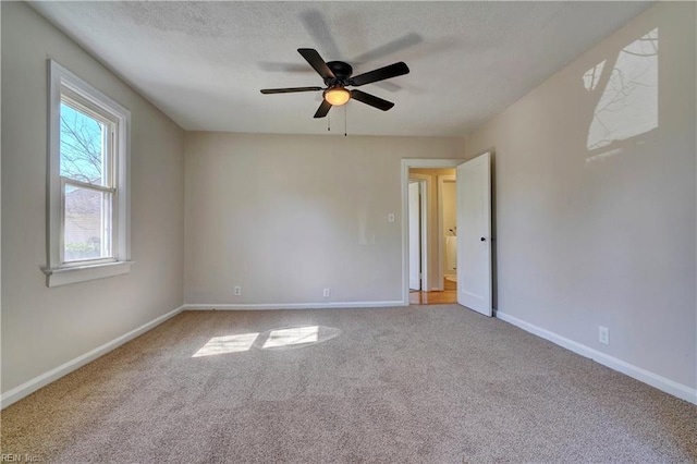 empty room featuring baseboards, carpet, ceiling fan, and a textured ceiling