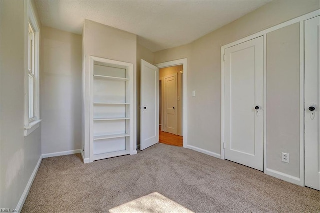 unfurnished bedroom featuring carpet and baseboards