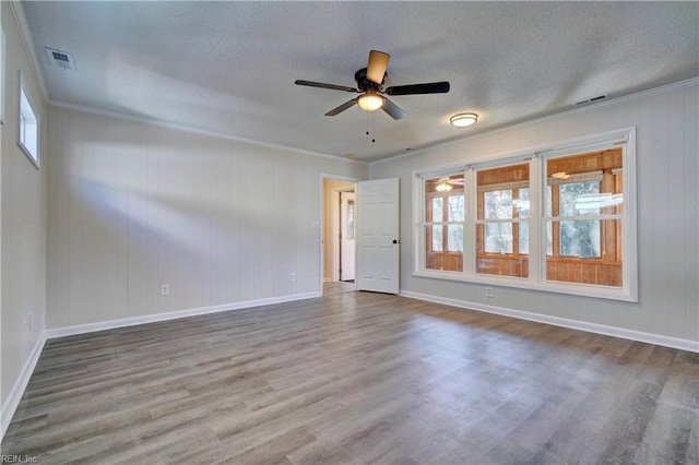 spare room with ceiling fan, wood finished floors, visible vents, and a textured ceiling