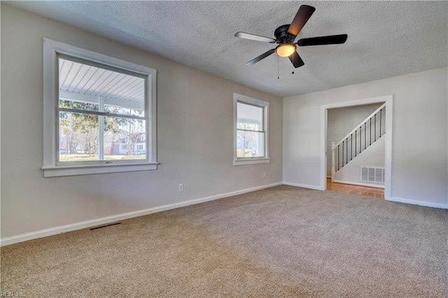 unfurnished room featuring carpet, visible vents, and baseboards