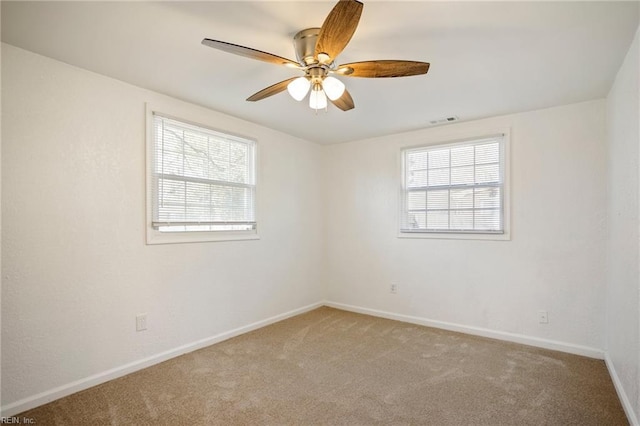 empty room with visible vents, baseboards, a ceiling fan, and carpet flooring