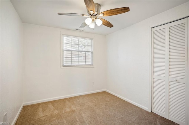 unfurnished bedroom featuring visible vents, baseboards, carpet, a closet, and a ceiling fan