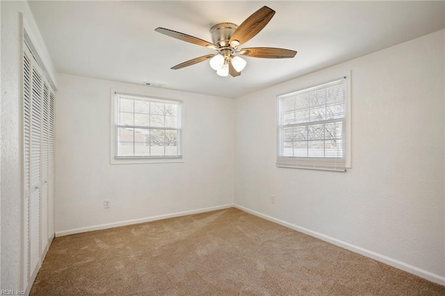 unfurnished bedroom with a closet, baseboards, a ceiling fan, and carpet flooring