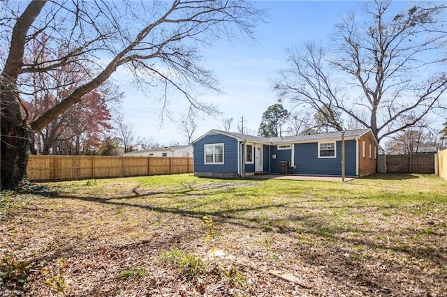 rear view of property featuring a patio area, a lawn, and a fenced backyard