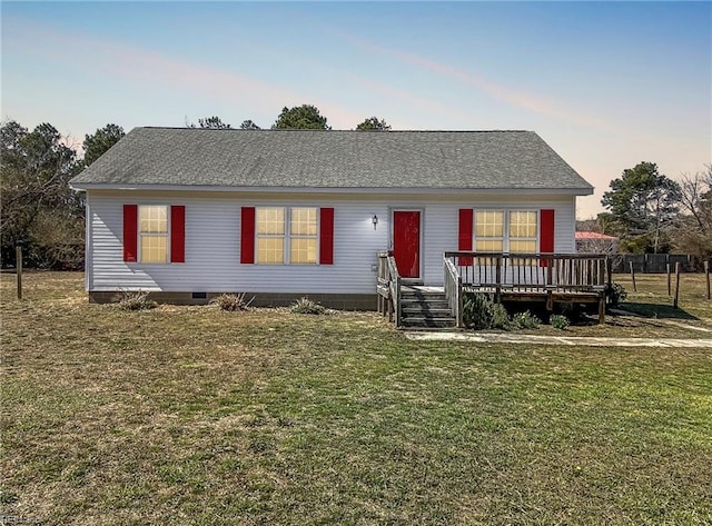 ranch-style house featuring crawl space, a wooden deck, roof with shingles, and a front lawn