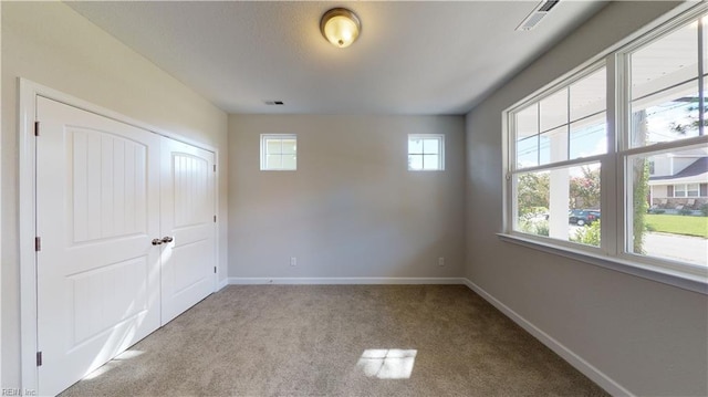 unfurnished room featuring visible vents, baseboards, and carpet